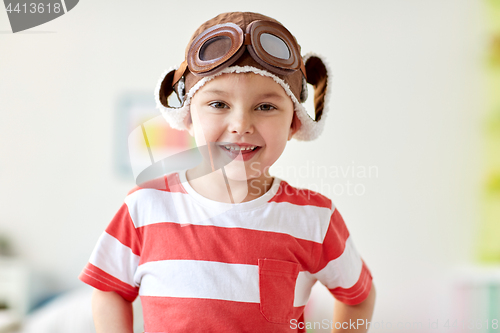 Image of happy little boy in pilot hat at home