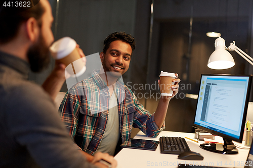 Image of creative team drinking coffee at night office