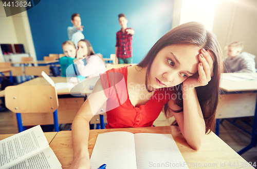 Image of students gossiping behind classmate back at school