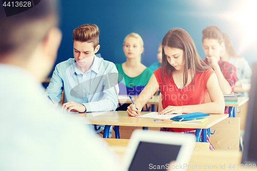 Image of group of students with books writing school test