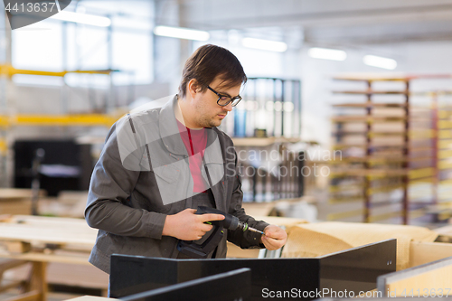 Image of assembler with screwdriver making furniture