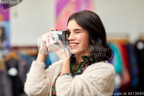 Image of smiling woman photographing by vintage film camera