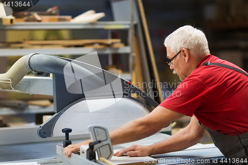Image of carpenter with panel saw and fibreboard at factory