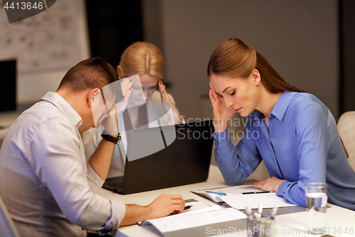 Image of business team with laptop working at night office