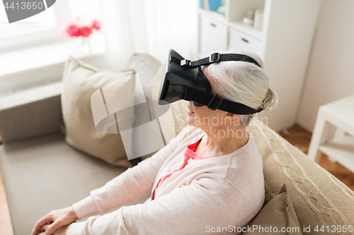 Image of old woman in virtual reality headset or 3d glasses