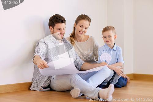 Image of happy family with blueprint moving to new home