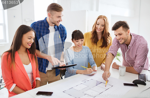 Image of creative team with blueprint working at office