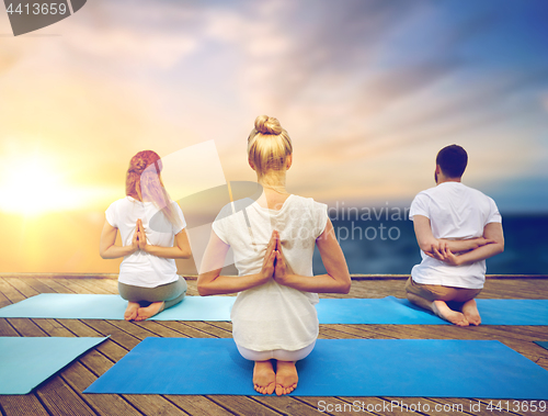 Image of group of people doing yoga outdoors