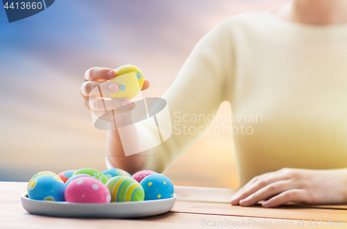 Image of close up of woman hands with colored easter eggs