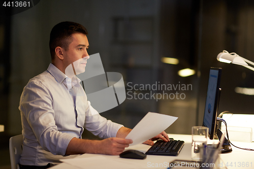 Image of businessman with computer working at night office