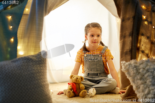 Image of little girl with toys in kids tent at home