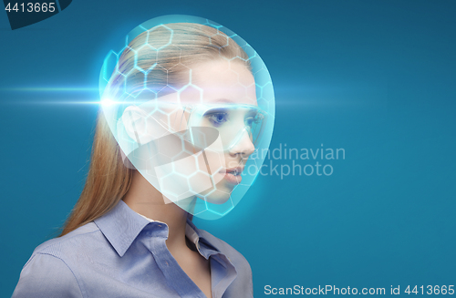 Image of woman in virtual helmet and goggles over blue