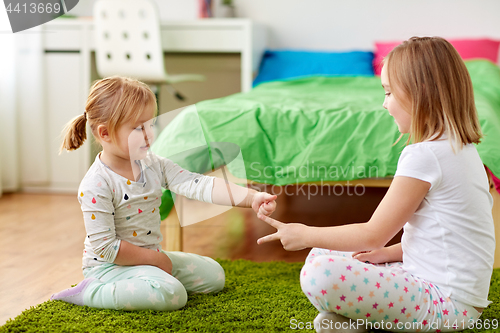 Image of girls playing rock-paper-scissors game at home