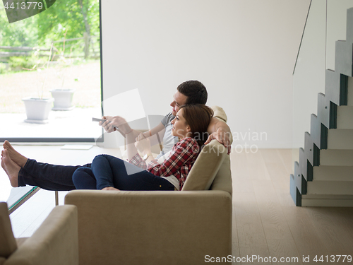 Image of Young couple on the sofa watching television