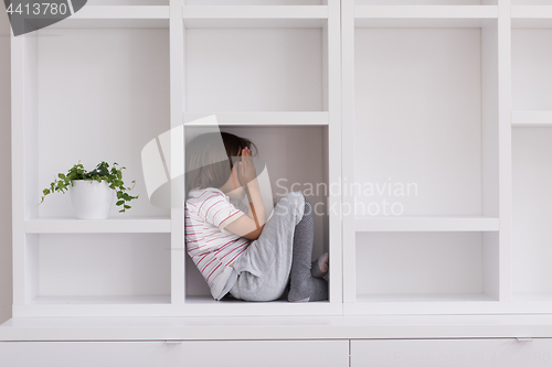 Image of young boy posing on a shelf