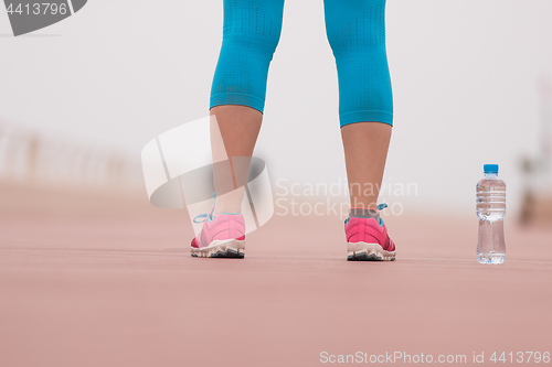 Image of close up on running shoes and bottle of water