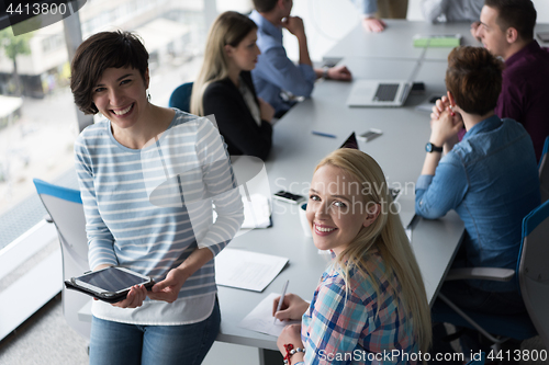 Image of Pretty Businesswomen Using Tablet In Office Building during conf