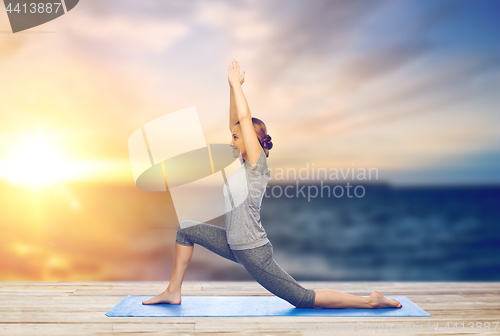 Image of happy woman making yoga in low lunge on mat