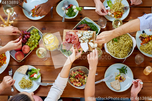 Image of group of people eating at table with food