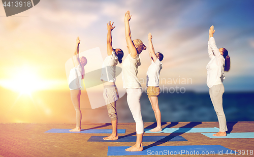 Image of group of people doing yoga outdoors