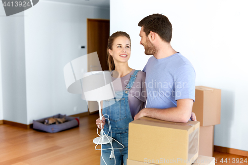 Image of couple with boxes and lamp moving to new home