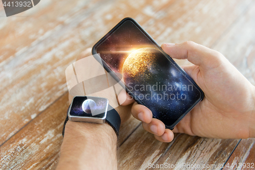 Image of close up of hands with smartphone and smart watch