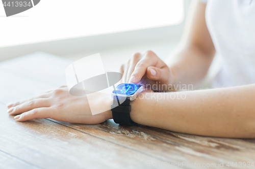 Image of close up of hands with bitcoin on smart watch