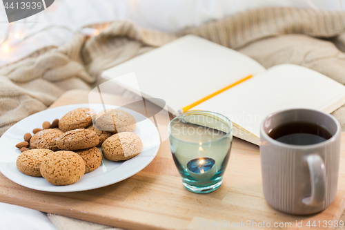 Image of cookies, tea and candle in holder at home