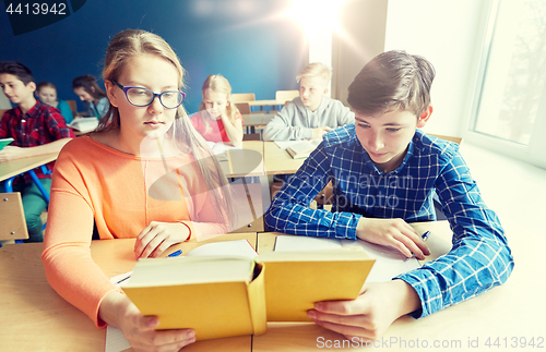 Image of students reading book at school lesson