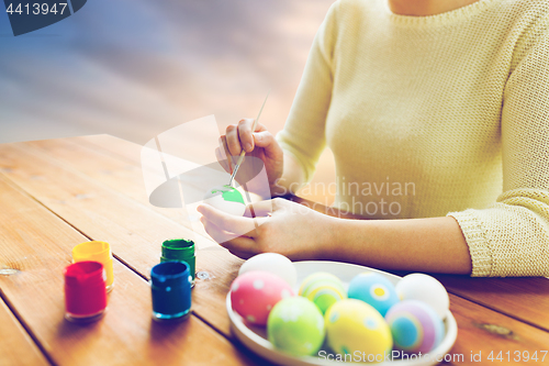 Image of close up of woman hands coloring easter eggs