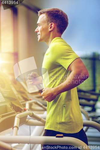 Image of smiling man exercising on treadmill in gym