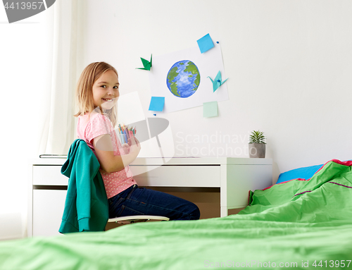 Image of happy girl doing homework or drawing at home