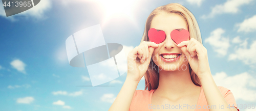 Image of happy young woman with red heart shapes on eyes