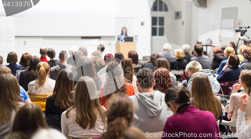 Image of Woman giving presentation in lecture hall at university.