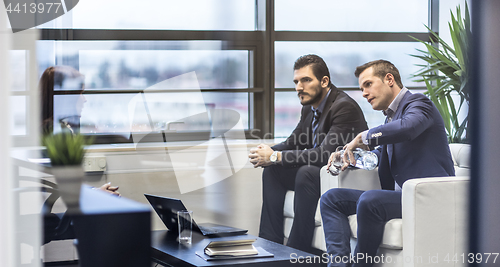 Image of Business people sitting at working meeting in modern corporate office.