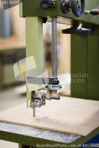 Image of jig saw machine sawing board at workshop