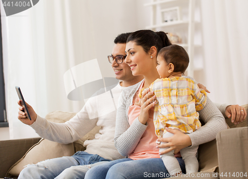 Image of mother, father and baby with tablet pc at home