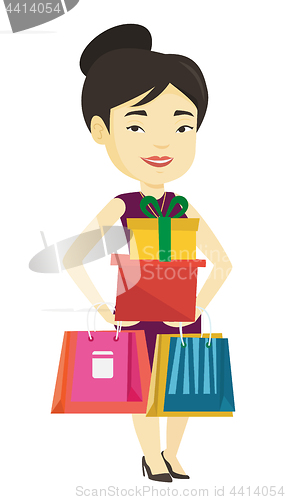 Image of Happy woman holding shopping bags and gift boxes.