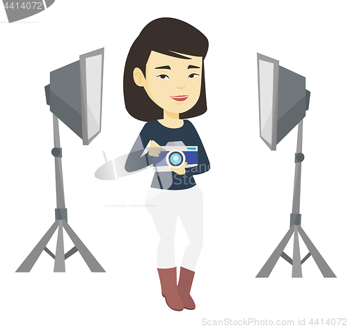 Image of Photographer with camera in photo studio.