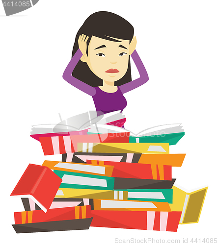 Image of Student sitting in huge pile of books.