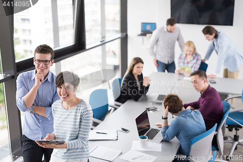 Image of Two Business People Working With Tablet in office