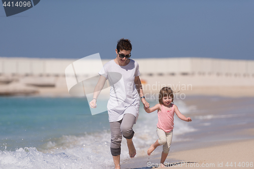 Image of mother and daughter running on the beach