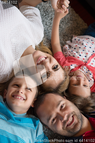 Image of happy family lying on the floor