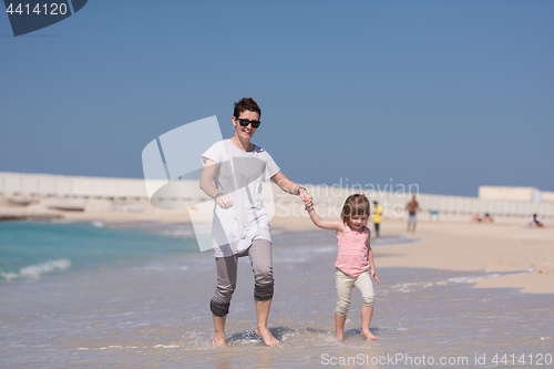 Image of mother and daughter running on the beach