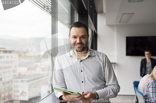 Image of Businessman Using Tablet In Office Building by window