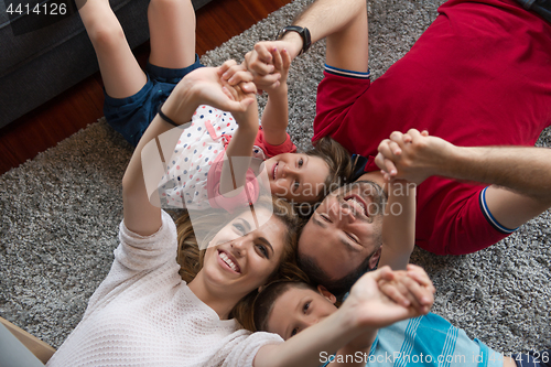 Image of happy family lying on the floor