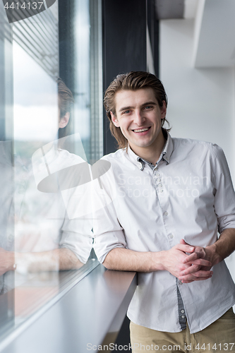 Image of young businessman in startup office by the window