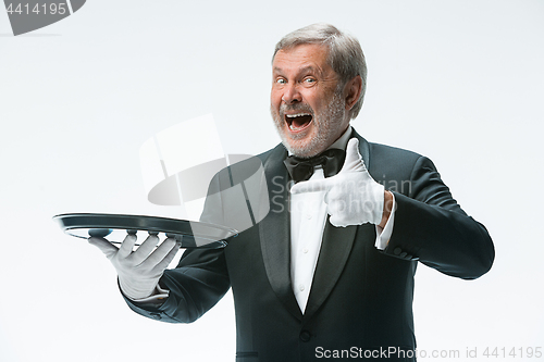 Image of Senior waiter holding tray