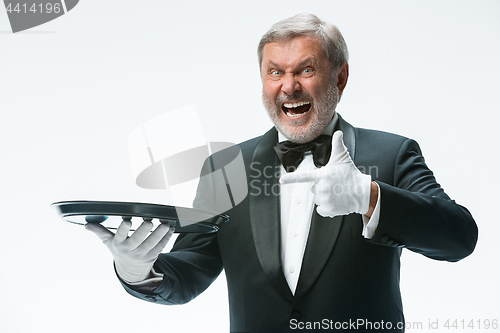 Image of Senior waiter holding tray