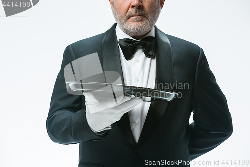 Image of Senior waiter holding tray